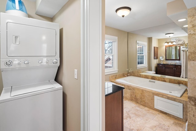 interior space with vanity, stacked washing maching and dryer, and a bath