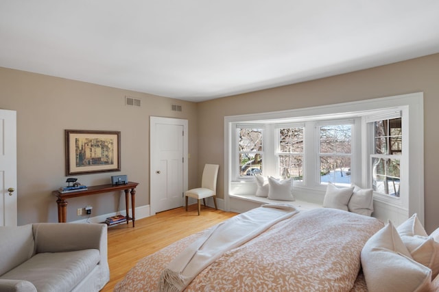 bedroom featuring baseboards, visible vents, and light wood-type flooring