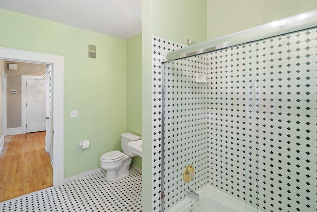 bathroom featuring toilet, baseboards, visible vents, and a stall shower