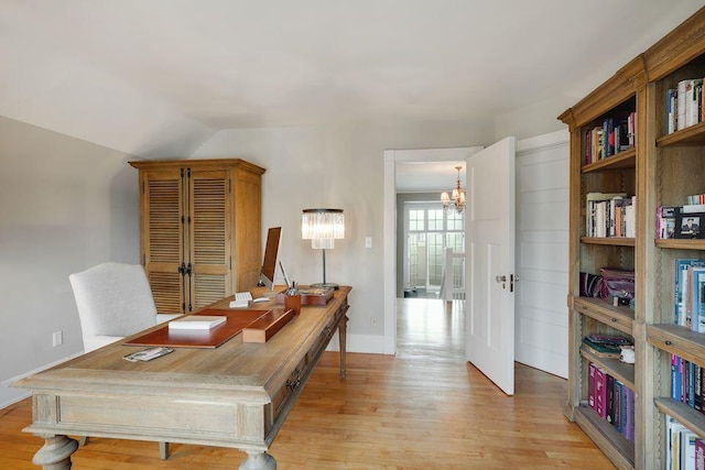 office featuring baseboards, light wood-style flooring, a chandelier, and vaulted ceiling