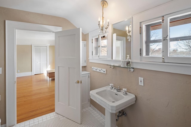 bathroom featuring a sink, tile patterned floors, lofted ceiling, and a wealth of natural light
