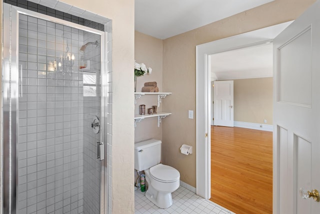 full bathroom featuring tile patterned floors, baseboards, a shower stall, and toilet