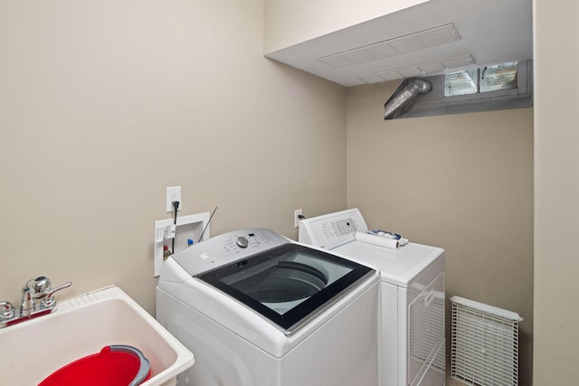 clothes washing area featuring a sink, visible vents, laundry area, and washing machine and clothes dryer