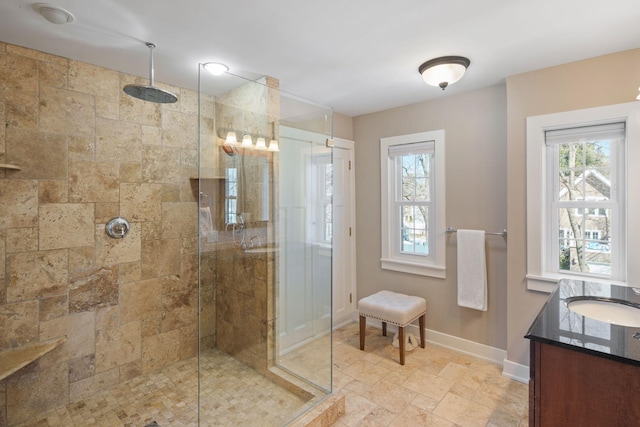 bathroom with vanity, baseboards, stone finish floor, and a stall shower