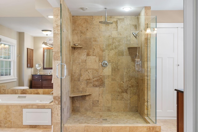 full bathroom with vanity, a garden tub, and a stall shower
