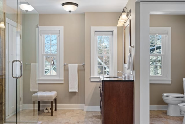 full bath featuring vanity, toilet, baseboards, a bidet, and a stall shower