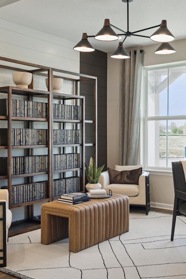 living area featuring baseboards and wood walls