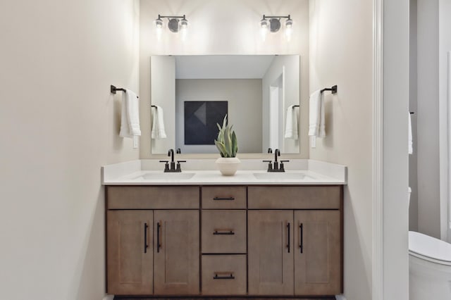 full bath featuring toilet and double vanity