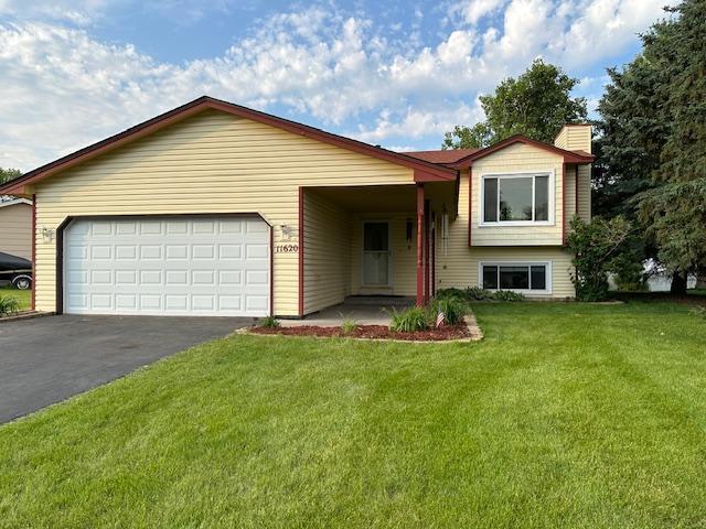 11620 Oregon Ave N, Champlin, MN 55316 - split level home with asphalt driveway, a front lawn, an attached garage, and a chimney