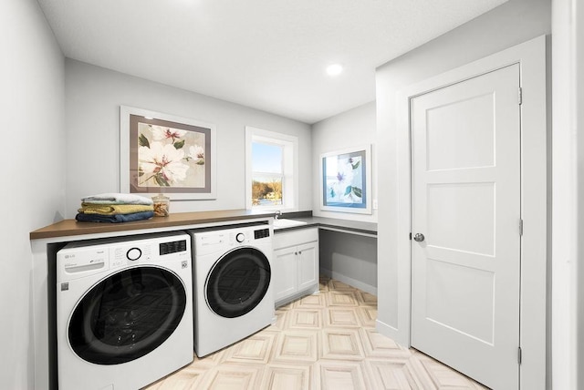 laundry room featuring a sink, cabinet space, washing machine and dryer, and baseboards
