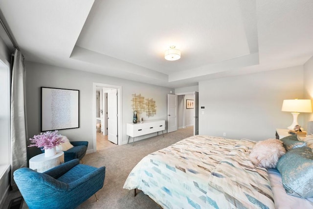 bedroom with a raised ceiling, baseboards, and light colored carpet