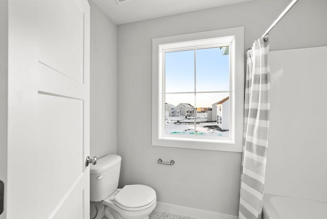 full bath featuring baseboards and toilet