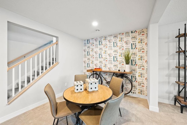 carpeted dining space with baseboards and stairs