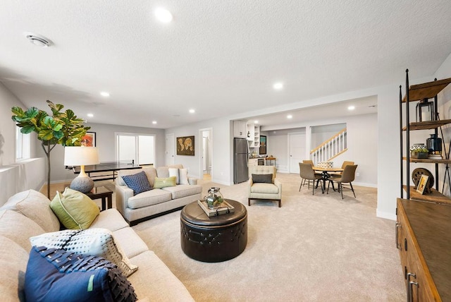 living area featuring light carpet, stairs, recessed lighting, and a textured ceiling