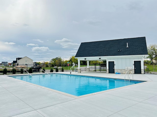 community pool with fence and a patio area