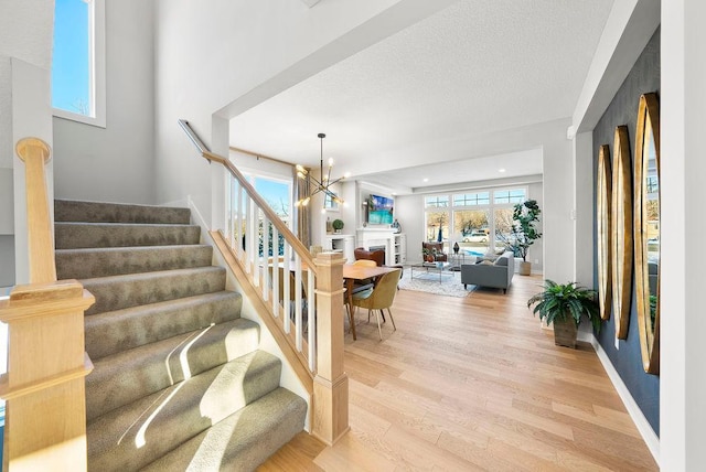 2712 Kensington Ave NE, Saint Michael, MN 55376 - staircase featuring wood finished floors, a chandelier, and a textured ceiling