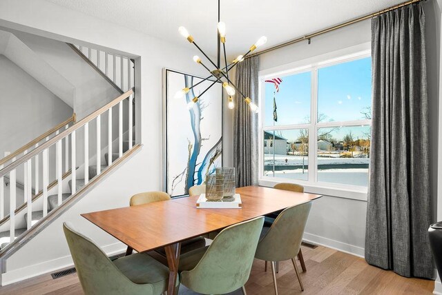 2712 Kensington Ave NE, Saint Michael, MN 55376 - dining area featuring a chandelier, stairway, baseboards, and wood finished floors