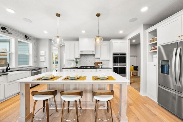 2712 Kensington Ave NE, Saint Michael, MN 55376 - kitchen with stainless steel appliances, a kitchen island, a breakfast bar area, decorative backsplash, and recessed lighting