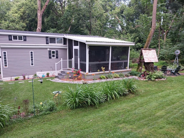 2945 County Road 4 SW Unit 69, Cokato, MN 55321 - rear view of property featuring a sunroom, a lawn, and a fire pit