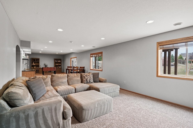 living room featuring light carpet, recessed lighting, plenty of natural light, and baseboards