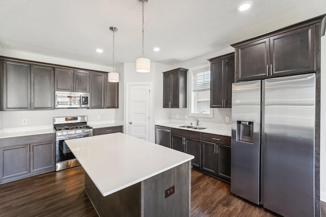 kitchen with light countertops, a sink, appliances with stainless steel finishes, dark wood-style flooring, and dark brown cabinets