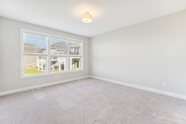 unfurnished room with carpet, baseboards, and visible vents