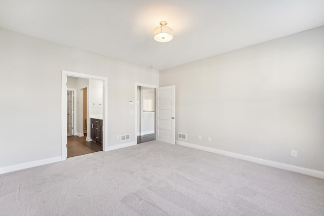 unfurnished bedroom with baseboards, visible vents, and dark carpet