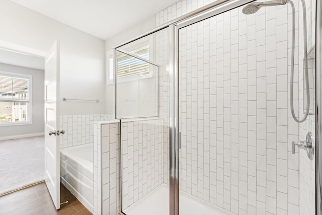 bathroom with a stall shower, a wealth of natural light, and a garden tub