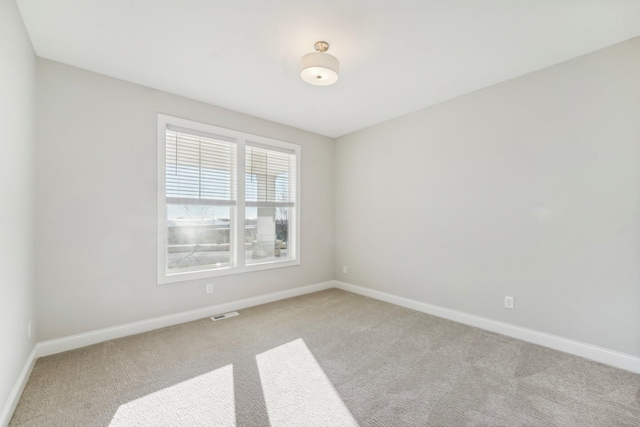 spare room featuring light carpet, baseboards, and visible vents