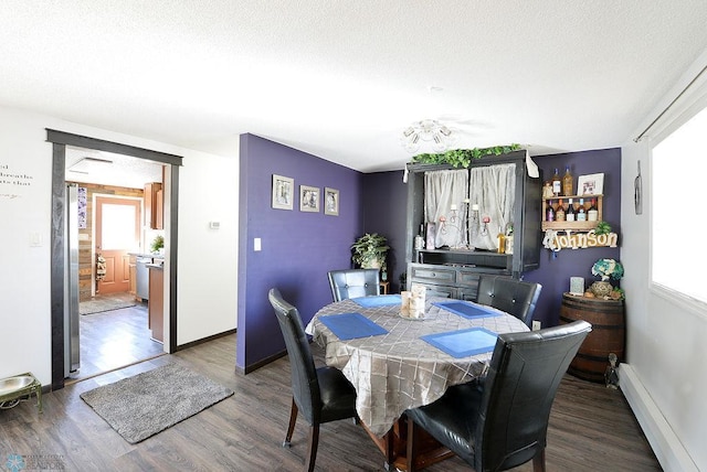 318 Morrison St, West Fargo, ND 58078 - dining space with baseboard heating, a textured ceiling, baseboards, and wood finished floors