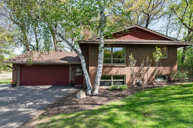 view of front of property with brick siding, an attached garage, asphalt driveway, and a front lawn