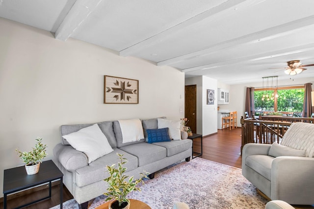 living room featuring beam ceiling, wood finished floors, and a ceiling fan