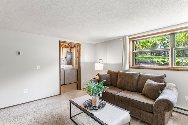 living room featuring washer and dryer, a textured ceiling, baseboards, baseboard heating, and light colored carpet