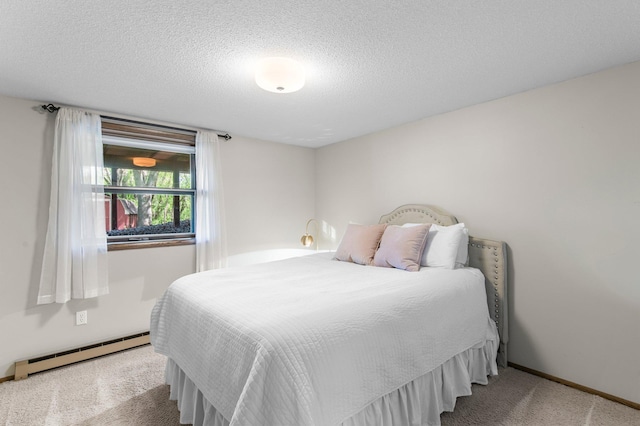 carpeted bedroom with a baseboard heating unit, a textured ceiling, and baseboards