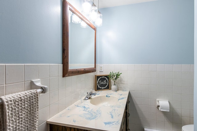 half bath featuring toilet, vanity, and tile walls