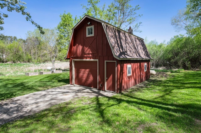 view of barn featuring driveway and a yard