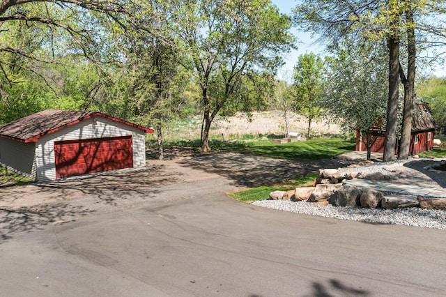 view of yard featuring a detached garage and an outbuilding