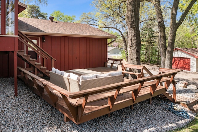 wooden terrace featuring an outdoor living space and an outbuilding
