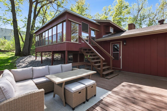 wooden deck with an outdoor living space, stairway, and a sunroom