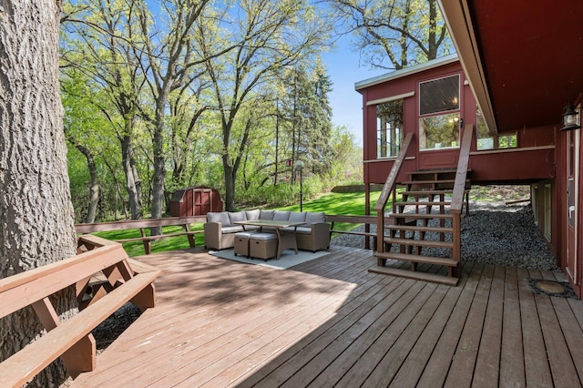 wooden terrace featuring a storage unit, outdoor lounge area, and an outbuilding