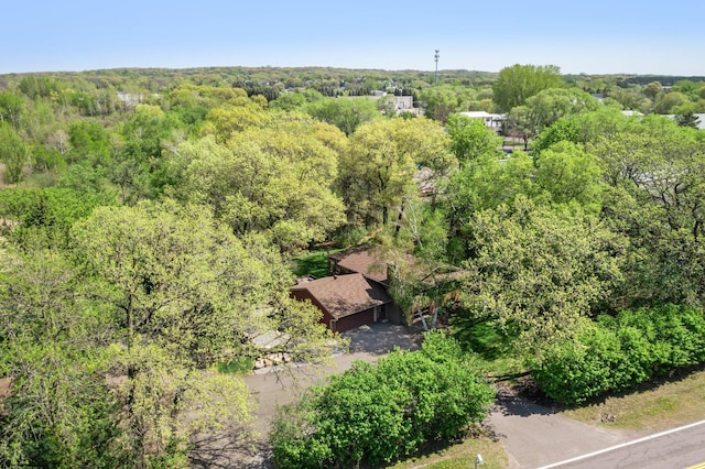 aerial view of property and surrounding area featuring a heavily wooded area