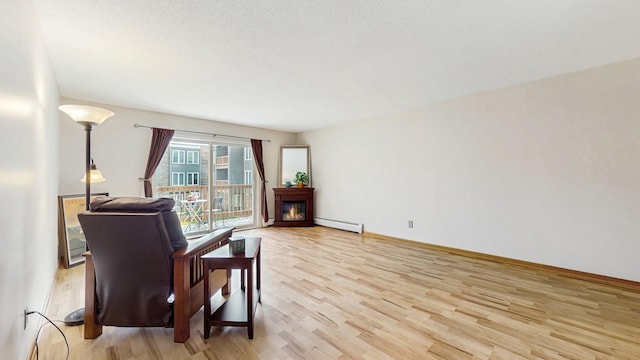 450 Ford Rd Unit 217, Saint Louis Park, MN 55426 - sitting room featuring a baseboard radiator, light wood-style floors, and a lit fireplace