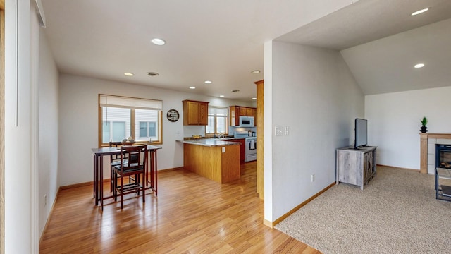 930 5th Ave, Goodhue, MN 55027 - kitchen with stainless steel electric range, white microwave, open floor plan, a peninsula, and brown cabinetry