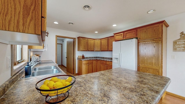 930 5th Ave, Goodhue, MN 55027 - kitchen featuring white refrigerator with ice dispenser, a sink, a peninsula, and visible vents