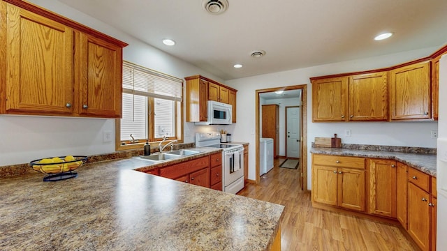 930 5th Ave, Goodhue, MN 55027 - kitchen featuring white appliances, washer / dryer, visible vents, light wood finished floors, and a sink