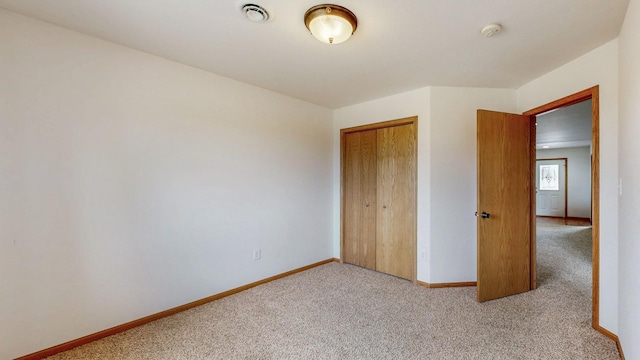 930 5th Ave, Goodhue, MN 55027 - unfurnished bedroom featuring visible vents, baseboards, a closet, and light carpet
