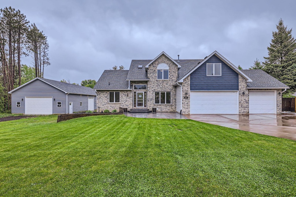 2833 162nd Ave NE, Ham Lake, MN 55304 - view of front of property with a front lawn, concrete driveway, roof with shingles, and a garage