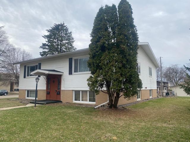 bi-level home featuring a front yard and brick siding
