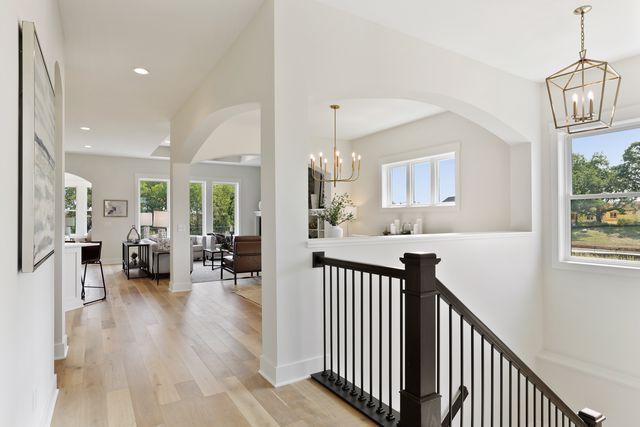 4036 Arbor Dr, Woodbury, MN 55129 - corridor featuring a chandelier, wood finished floors, recessed lighting, and arched walkways