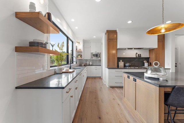kitchen with open shelves, a sink, appliances with stainless steel finishes, and dark countertops